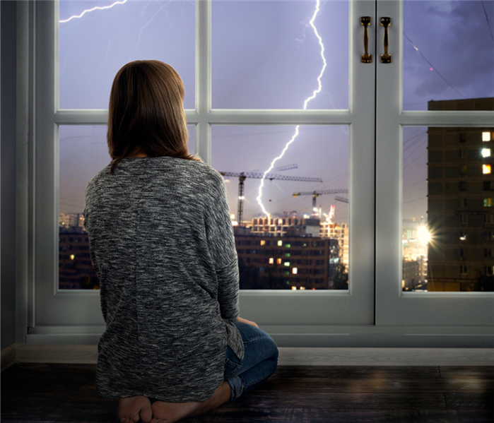 Woman watching storm out her window